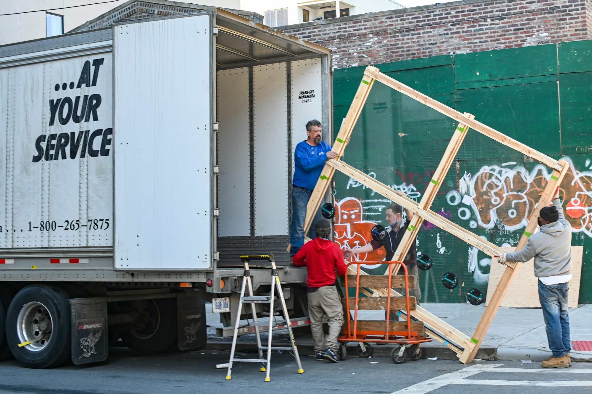 Menschen entladen Umzugswagen